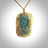 A photo of a New Zealand whale bone, Aotea Stone, ruby and sapphire face pendant. This is a one off, statement piece - hand crafted here in New Zealand by Jeremy. Unique Art to Wear. Gifts for all lovers of hand made Art to Wear. One only collectors pendant. Delivery is free worldwide. Included is a wooden box